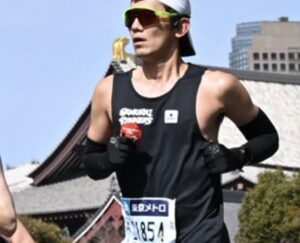 マラソン中にエネルギージェルを補給するランナー